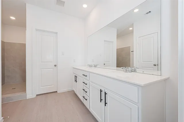 a bathroom with double sink and a mirror
