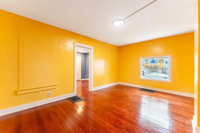 a view of an empty room with wooden floor
