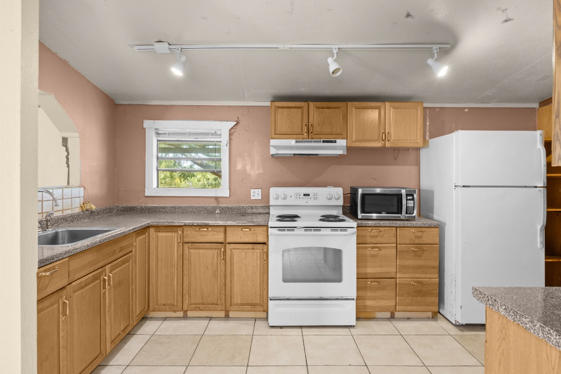 147 Community Center Road Rosanky, TX 78953 - Photo 10 of 33 a kitchen with a stove a refrigerator and a sink