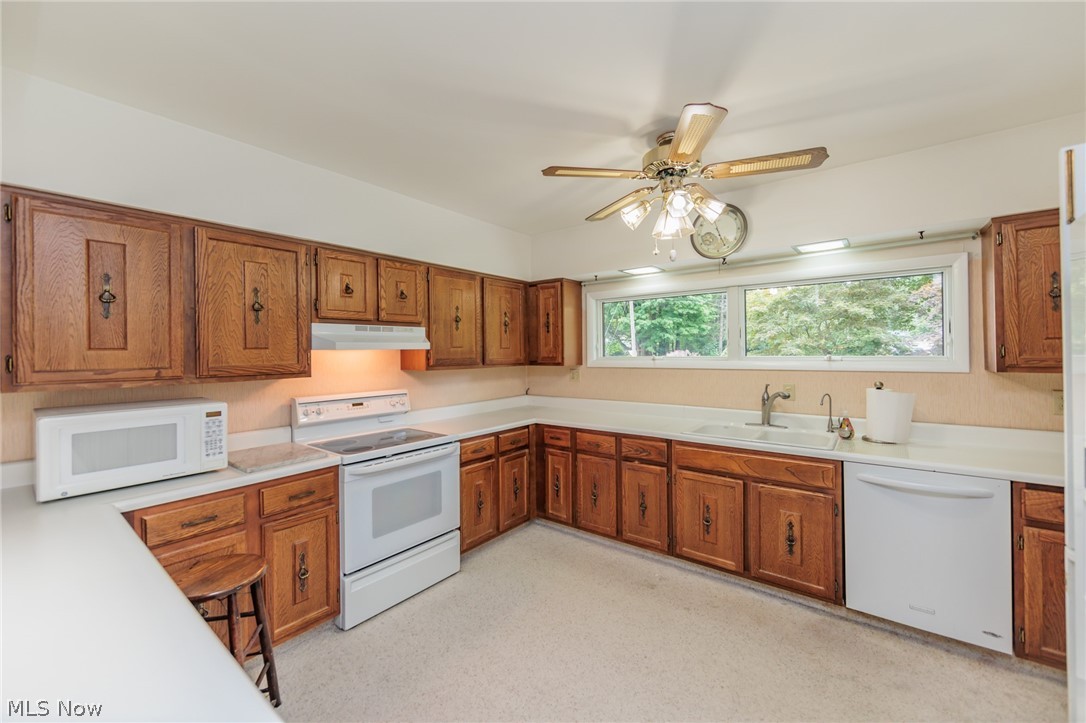 425 Bittersweet Road Akron, OH 44333 - Photo 26 of 50 Kitchen featuring light colored carpet, white appliances, sink, and ceiling fan