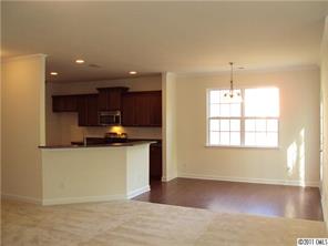 233 Lorraine Road Fort Mill, SC 29708 - Photo 7 of 16 a view of a kitchen with kitchen island a sink wooden floor and a counter top space