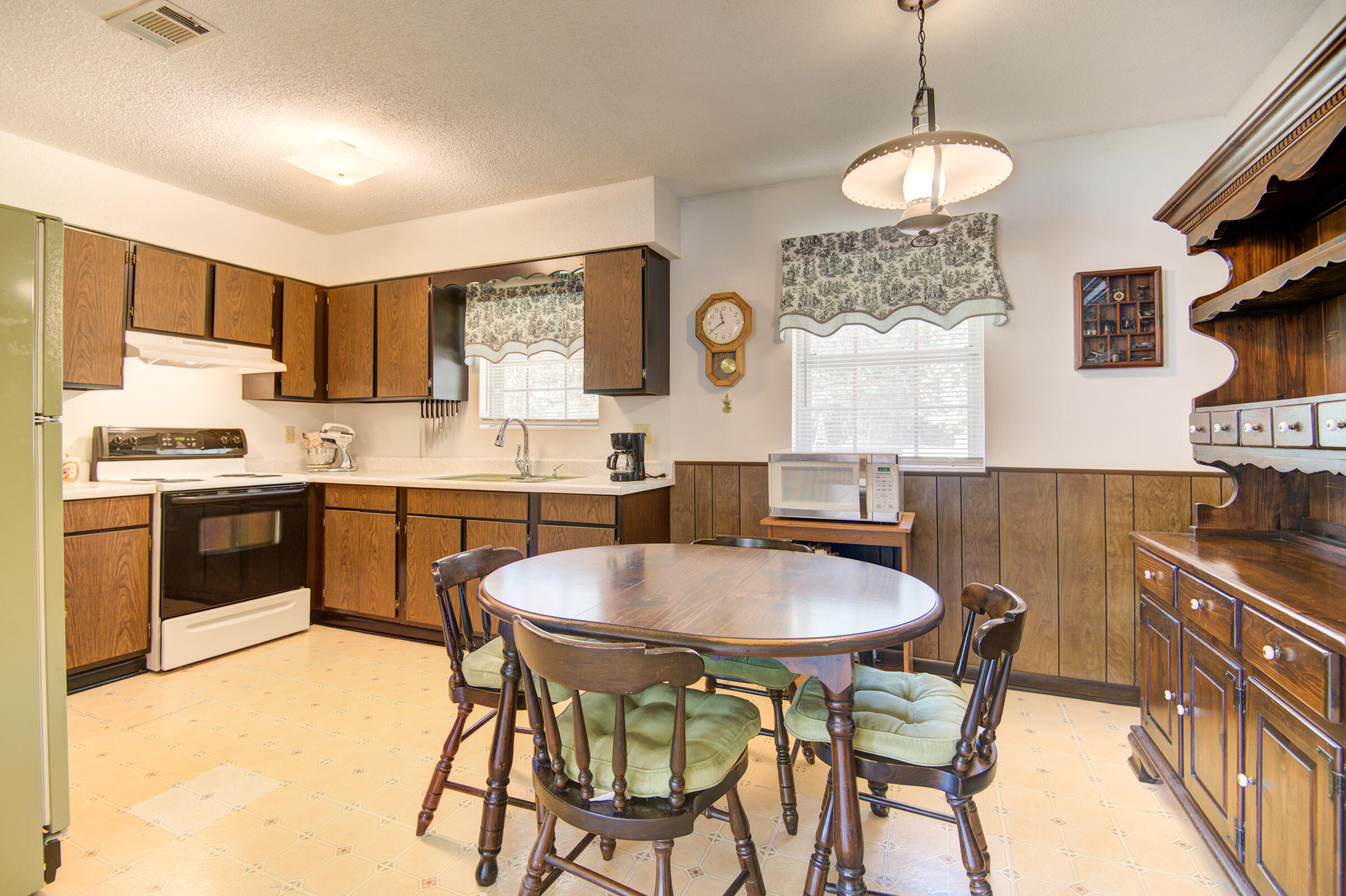 4826 Primrose Street Crestview, FL 32539 - Photo 21 of 25 a kitchen with stainless steel appliances granite countertop a stove a sink dishwasher a stove a refrigerator with a dining table and chairs