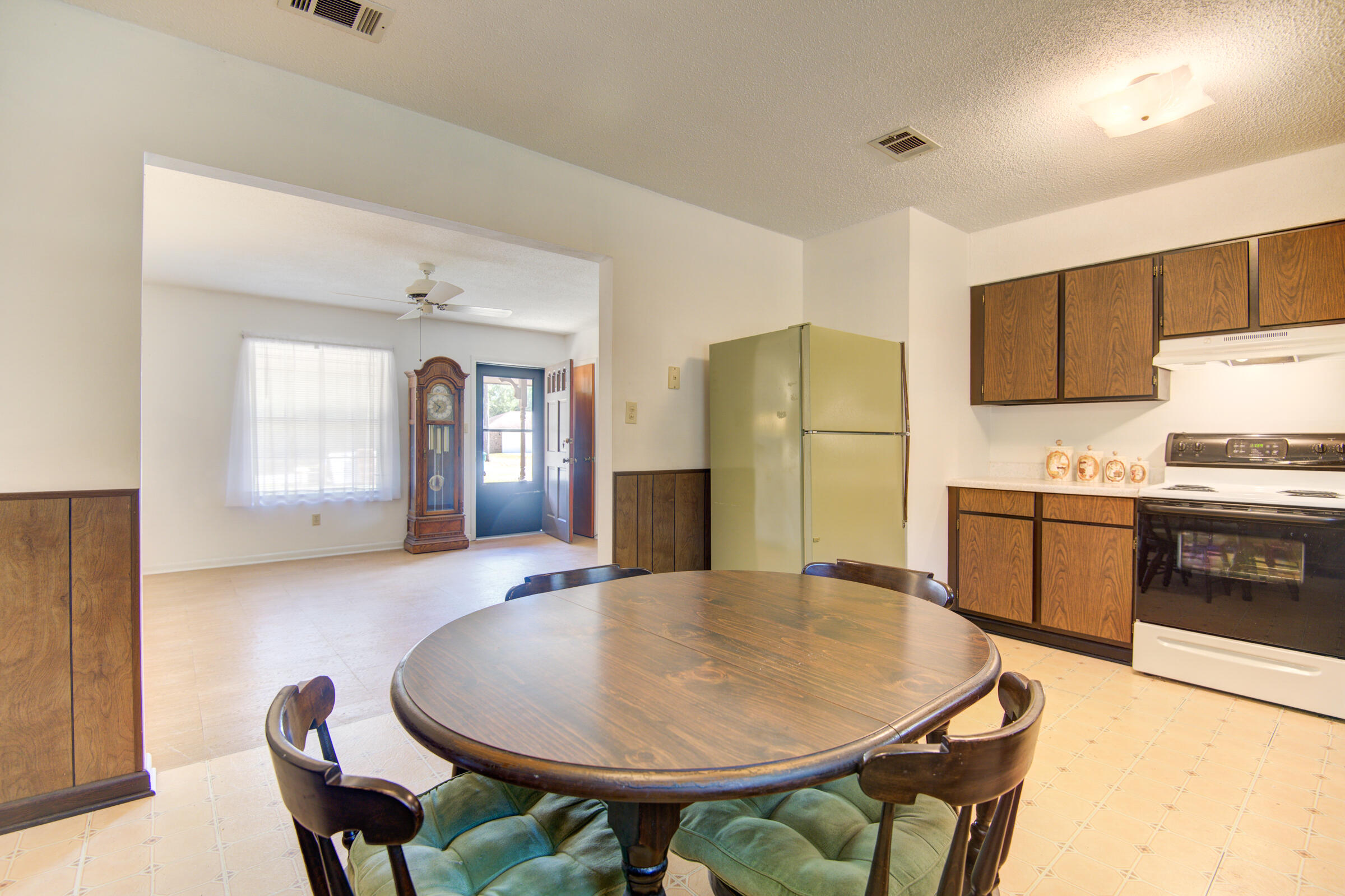 4826 Primrose Street Crestview, FL 32539 - Photo 4 of 25 a kitchen with stainless steel appliances granite countertop a refrigerator a stove a sink a dining table and chairs