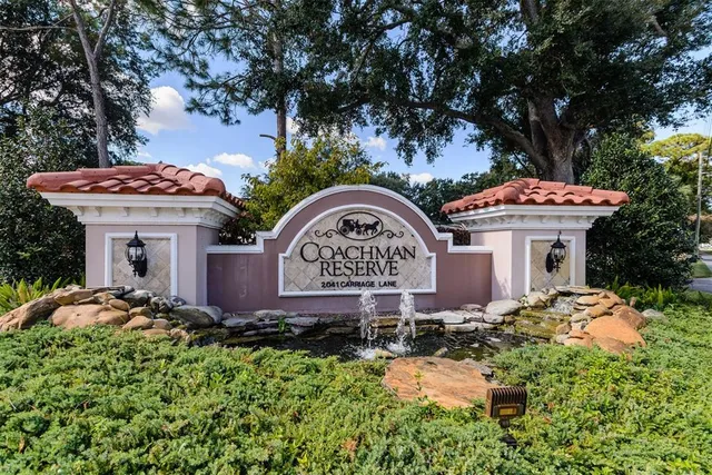 a view of a house with a yard and a large tree