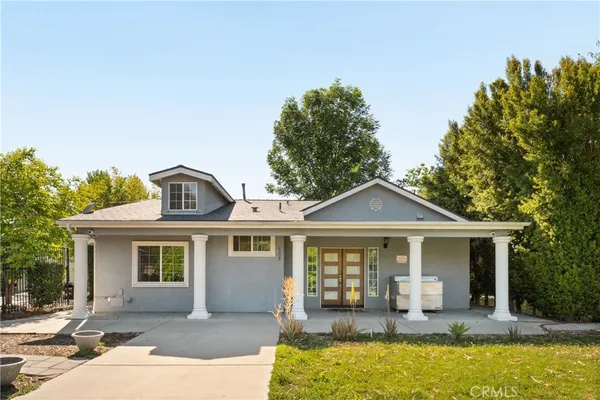 a front view of a house with a yard and seating space