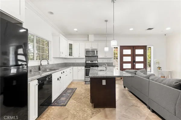 a large kitchen with kitchen island a sink appliances and cabinets