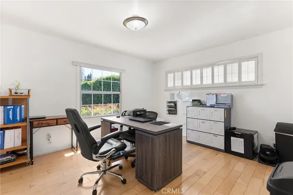 a view of a workspace with furniture and a window