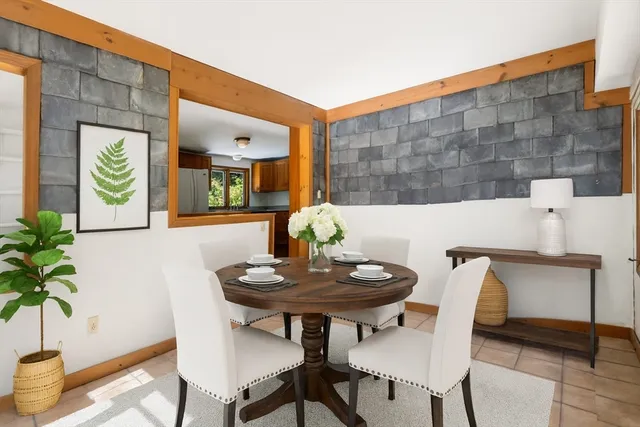 a front view of house with yard and trees in the background