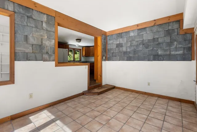 an empty room with windows and fireplace
