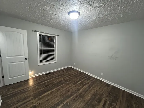 an empty room with wooden floor and door