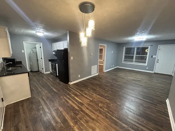 a view of empty room with wooden floor and window