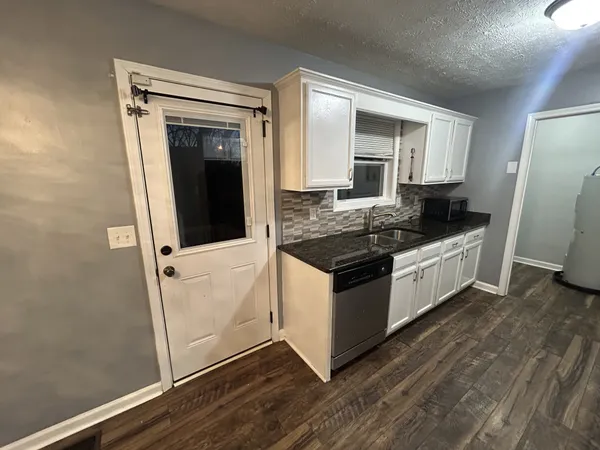 a kitchen with granite countertop a stove and a refrigerator