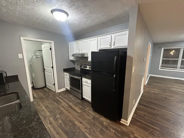 a kitchen with a refrigerator and a stove