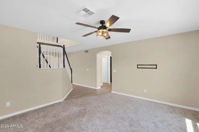 an empty room with windows and fan