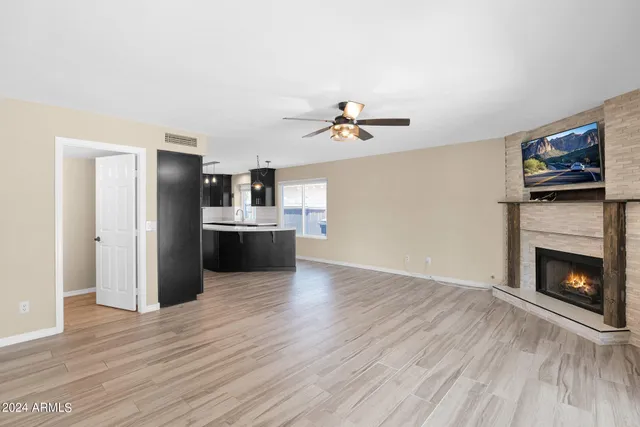 a view of a kitchen with a sink a fireplace and wooden floor
