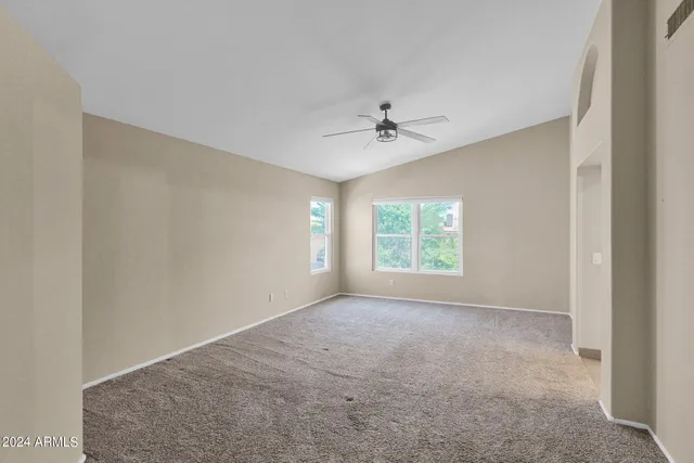 a view of a big room with windows and chandelier fan