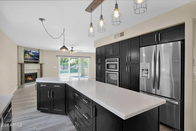 a kitchen with kitchen island a counter space cabinets and stainless steel appliances