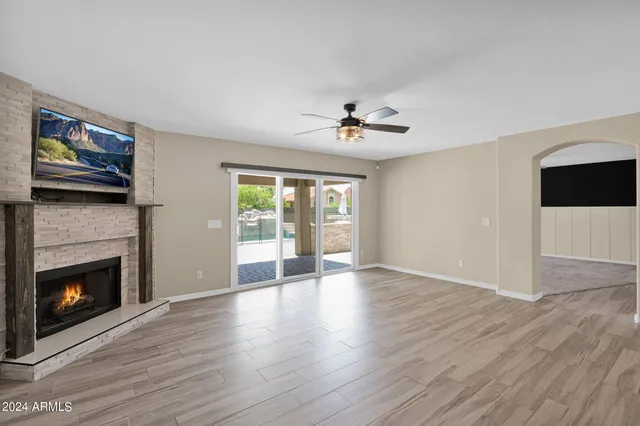 a view of an empty room with a fireplace and a window