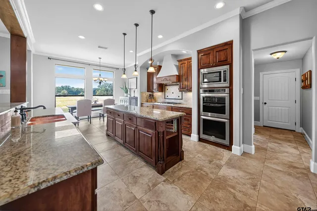 a large kitchen with stainless steel appliances granite countertop a large counter top and a stove