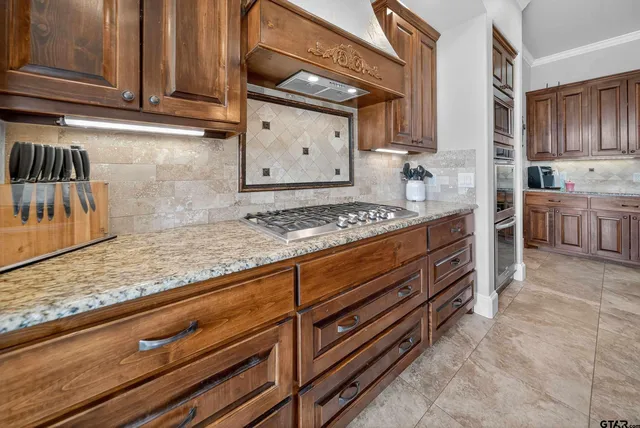a kitchen with stainless steel appliances granite countertop a sink stove and cabinets