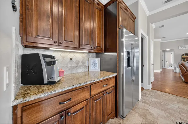 a kitchen with granite countertop stainless steel appliances a sink and refrigerator