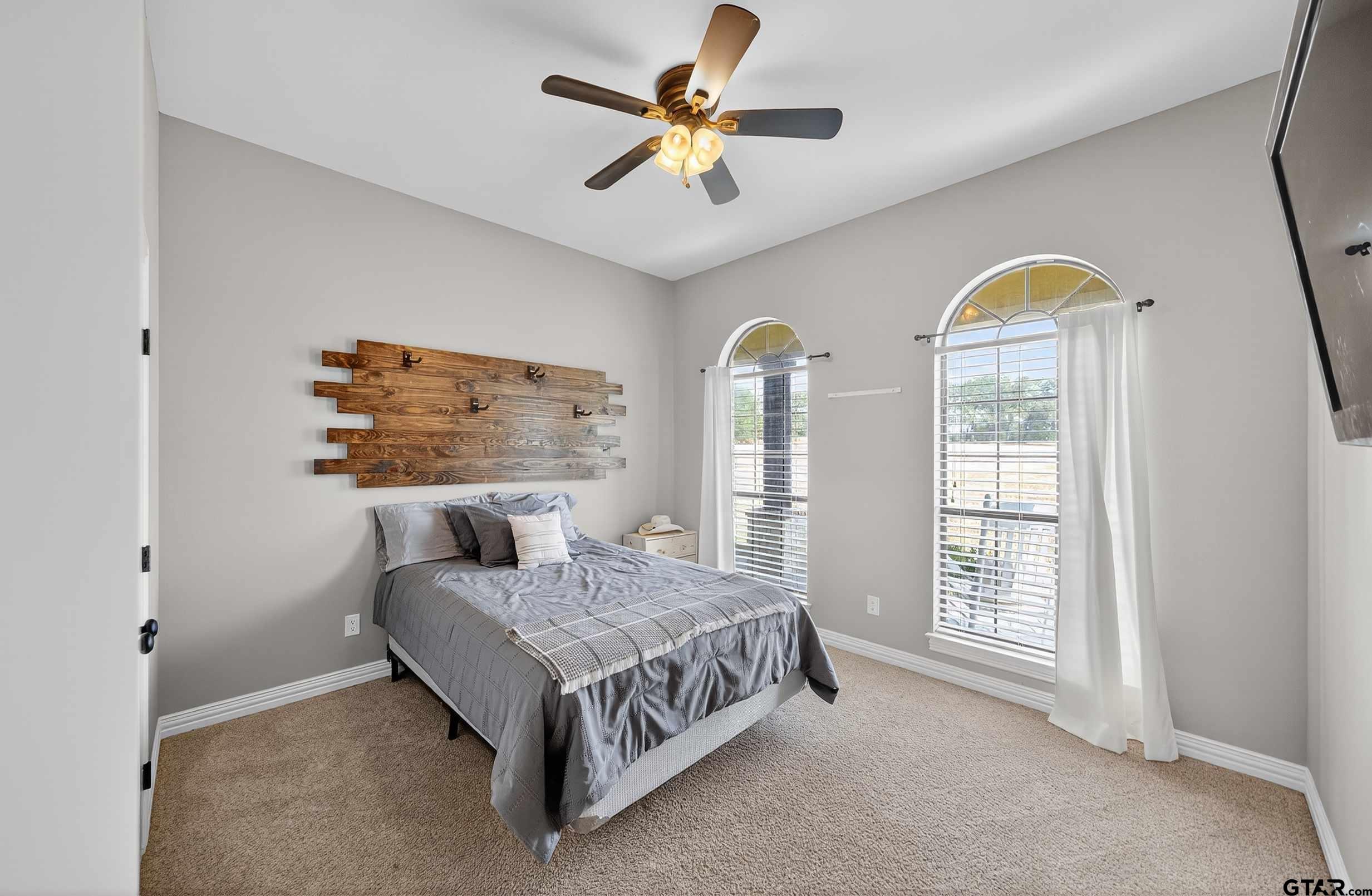 2621 Anderson County Road Palestine, TX 75803 - Photo 20 of 46 a bedroom with a bed and a chandelier