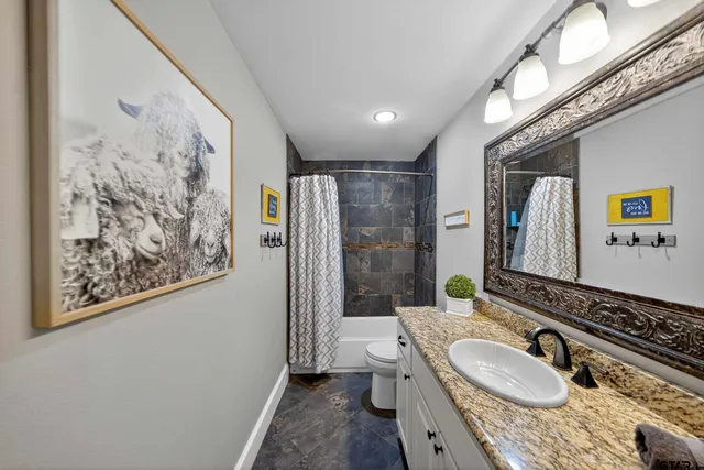 a bathroom with a granite countertop double vanity sink a mirror a shower and a bathtub