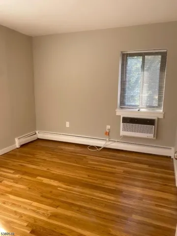 a view of a room with wooden floor and cabinet