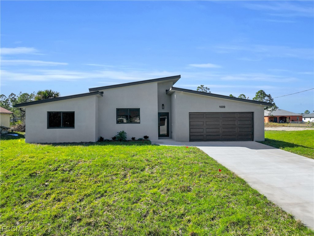 1011 State Avenue Lehigh Acres, FL 33972 - Photo 1 of 34 a house view with a garden space