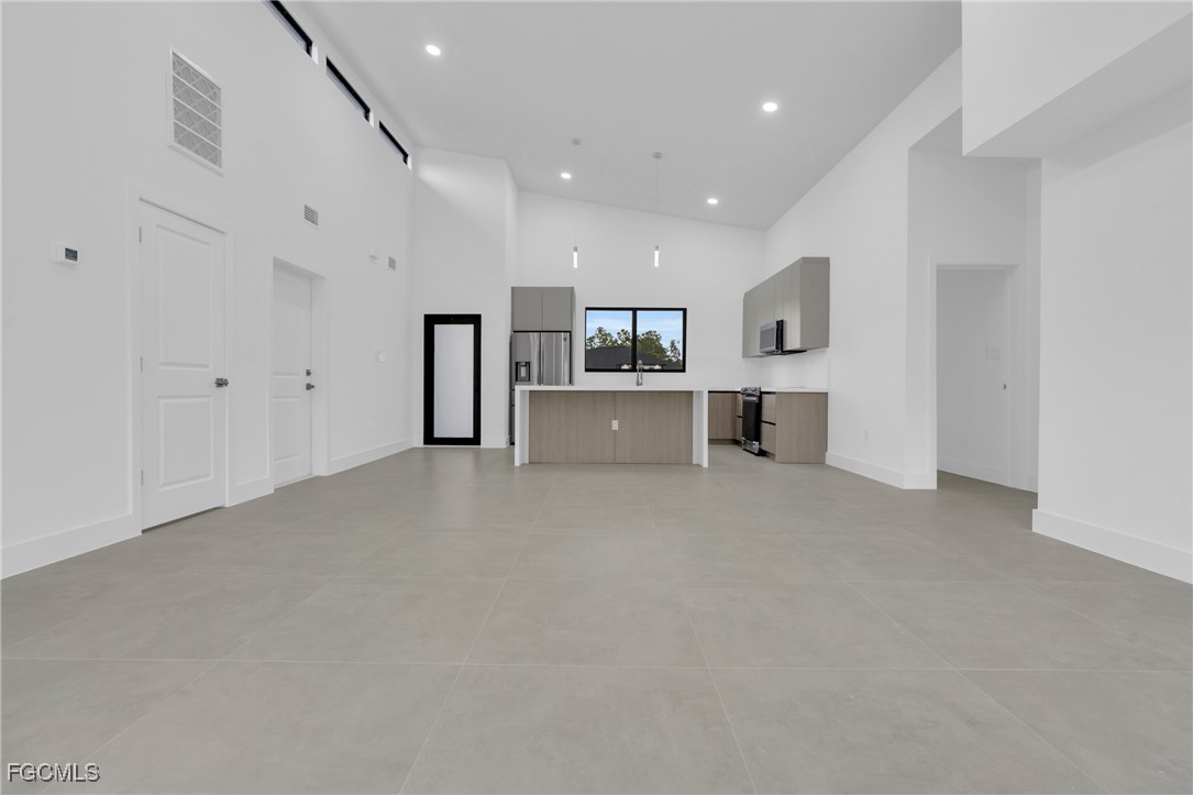 1011 State Avenue Lehigh Acres, FL 33972 - Photo 11 of 34 a large white kitchen with cabinets and a fireplace