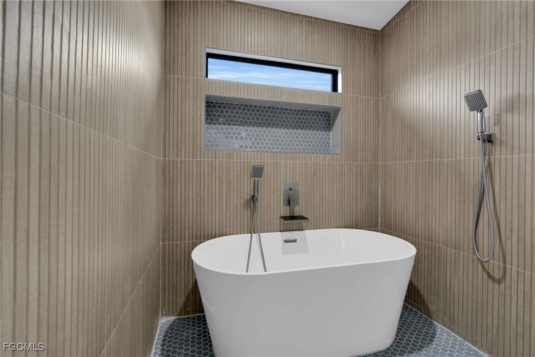 1011 State Avenue Lehigh Acres, FL 33972 - Photo 20 of 34 a bathroom with a bathtub and shower