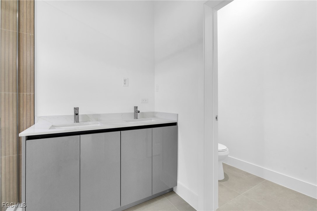 1011 State Avenue Lehigh Acres, FL 33972 - Photo 21 of 34 a bathroom with a double vanity sink and mirror