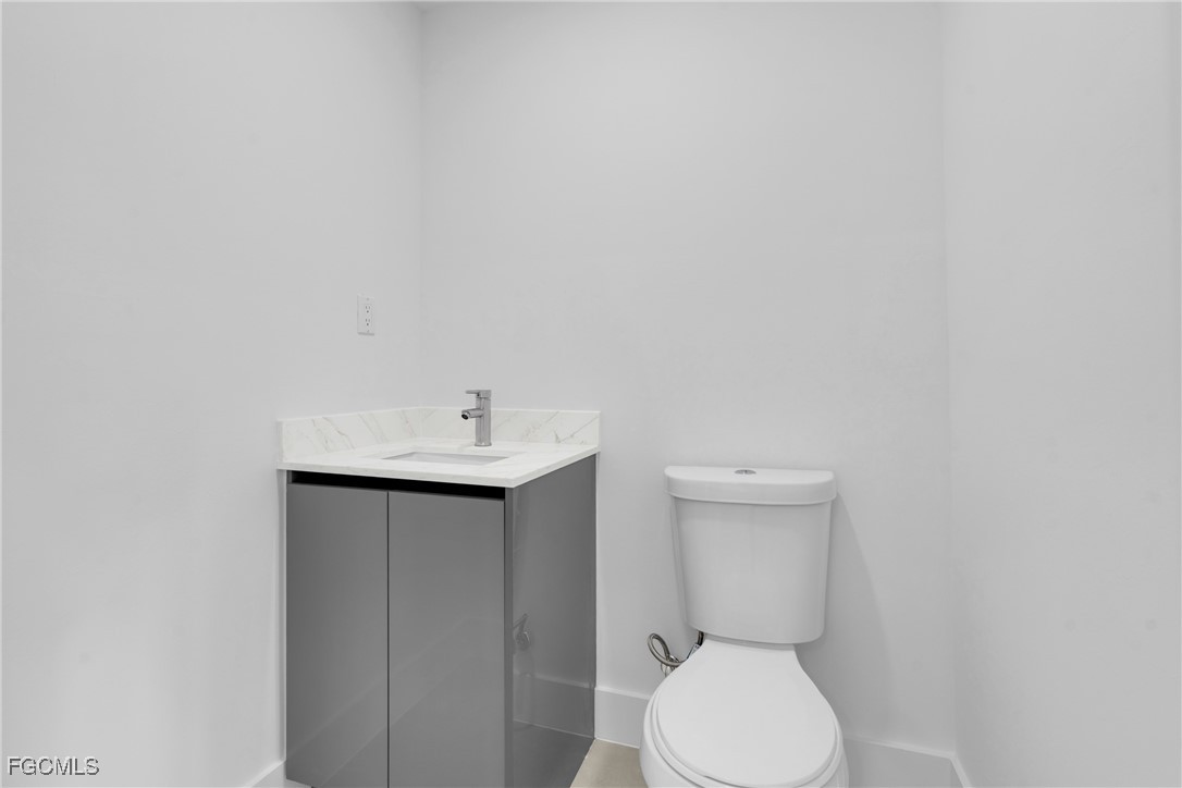 1011 State Avenue Lehigh Acres, FL 33972 - Photo 27 of 34 a bathroom with a toilet sink and mirror