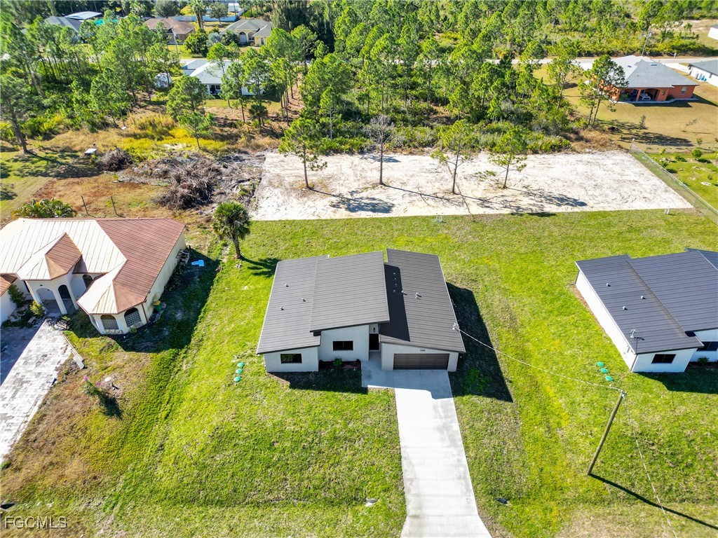 1011 State Avenue Lehigh Acres, FL 33972 - Photo 30 of 34 an aerial view of a house with yard swimming pool and outdoor seating