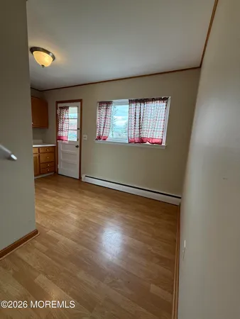 an empty room with windows and cabinet