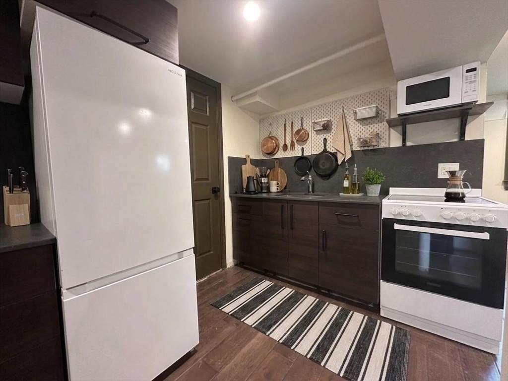 64 Goodenough Street, Unit G Boston, MA 02135 - Photo 2 of 6 a kitchen with stainless steel appliances granite countertop a refrigerator and a sink