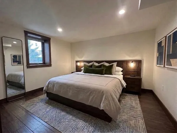 a bedroom with a bed and wooden floor