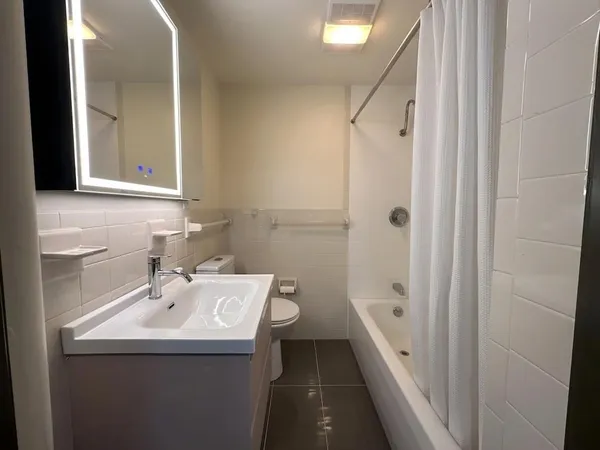 a bathroom with a sink a toilet and shower