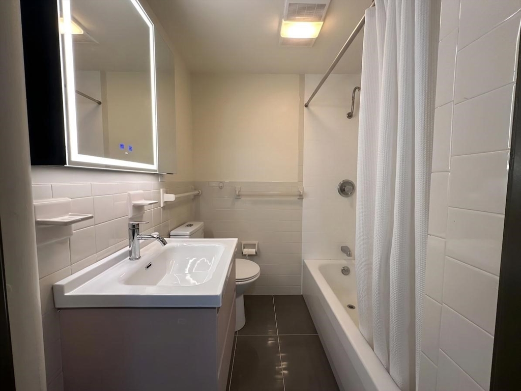 64 Goodenough Street, Unit G Boston, MA 02135 - Photo 6 of 6 a bathroom with a sink a toilet and shower