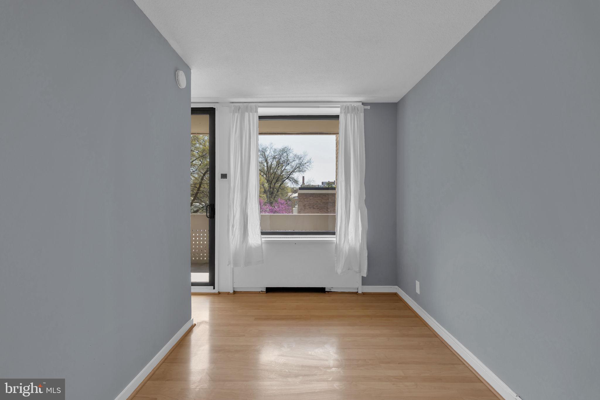 1245 4th Street Southwest, Unit E210 Washington, DC 20024 - Photo 11 of 28 a view of an empty room with wooden floor and a window