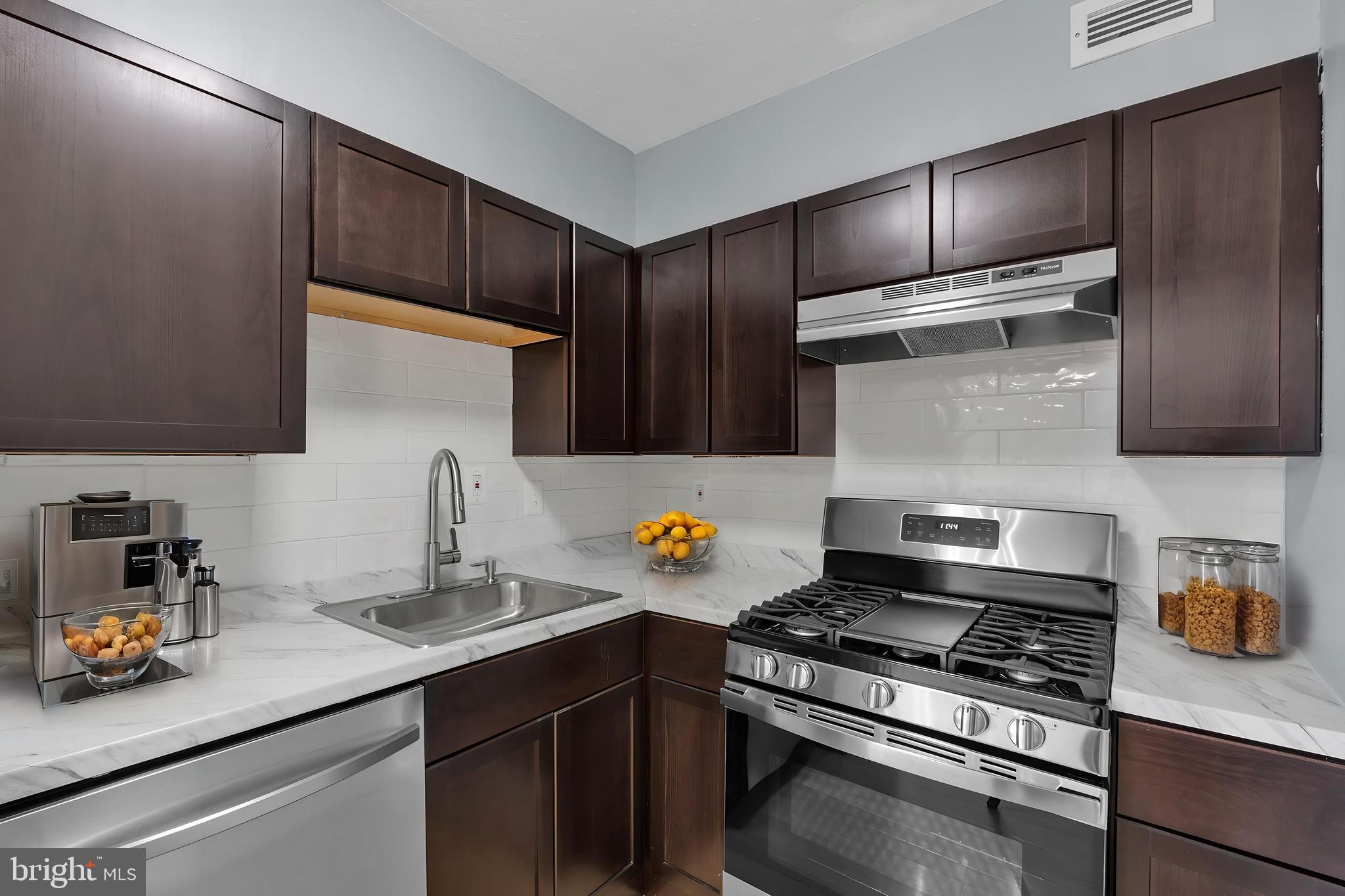 1245 4th Street Southwest, Unit E210 Washington, DC 20024 - Photo 12 of 28 a kitchen with stainless steel appliances a sink stove and cabinets