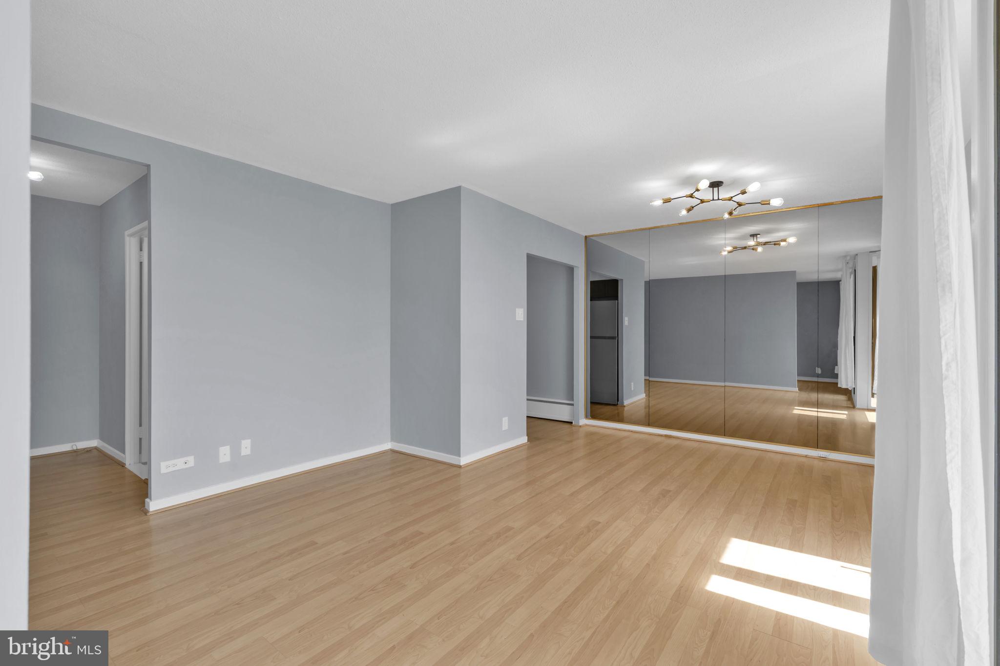 1245 4th Street Southwest, Unit E210 Washington, DC 20024 - Photo 8 of 28 a view of an empty room with wooden floor and a window
