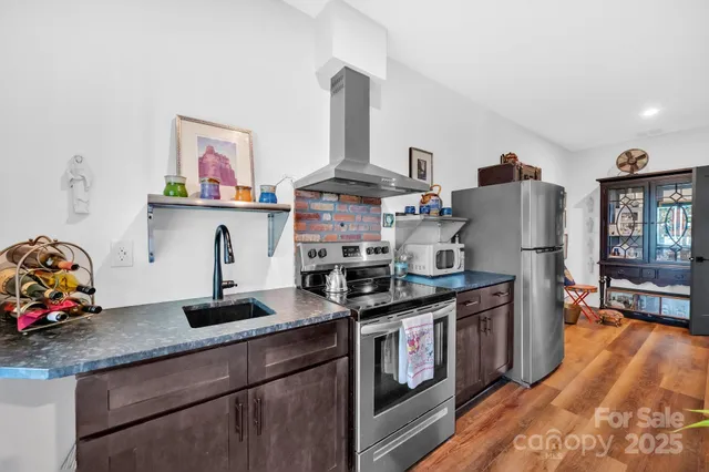 a kitchen with stainless steel appliances granite countertop a stove refrigerator and cabinets