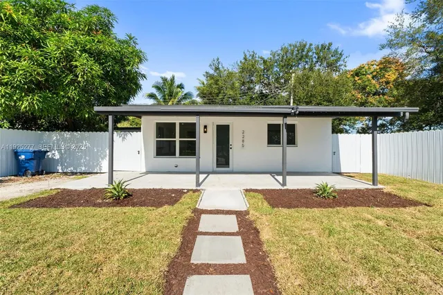 a house with yard and trees in the background