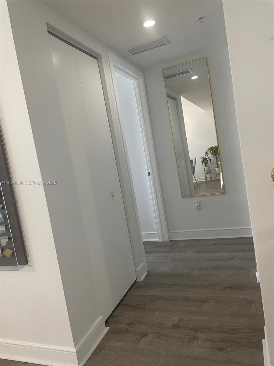 185 Southwest 7th Street, Unit 2014 Miami, FL 33130 - Photo 23 of 38 an empty room with wooden floor and white walls