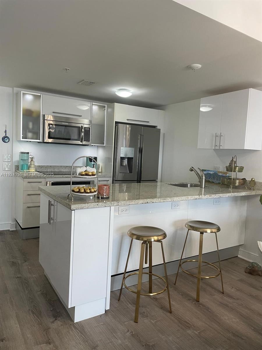 185 Southwest 7th Street, Unit 2014 Miami, FL 33130 - Photo 25 of 38 a kitchen with stainless steel appliances granite countertop a table chairs sink and cabinets