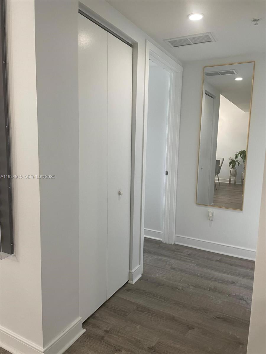 185 Southwest 7th Street, Unit 2014 Miami, FL 33130 - Photo 31 of 38 an empty room with wooden floor and mirror