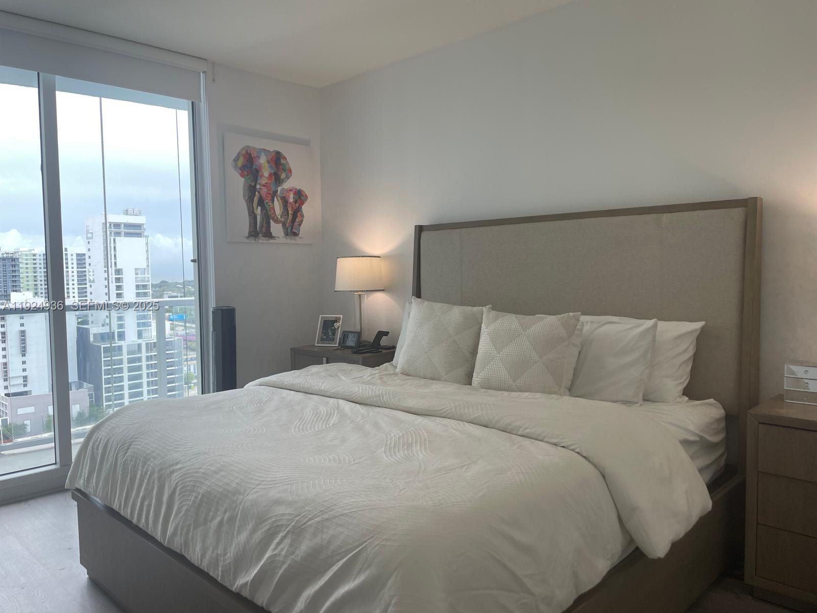 185 Southwest 7th Street, Unit 2014 Miami, FL 33130 - Photo 10 of 38 a large bed sitting in a bedroom next to a large window