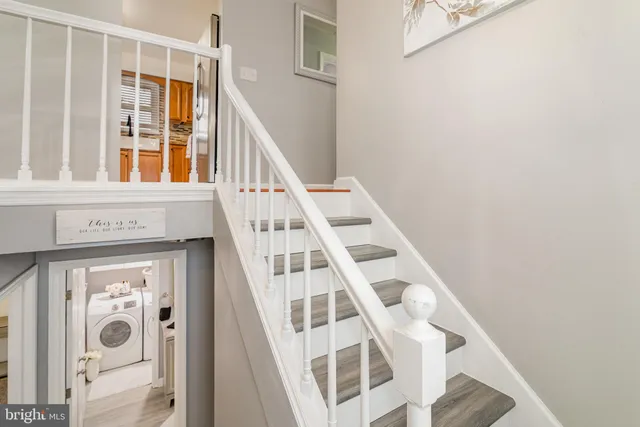 a view of staircase with large window and white walls