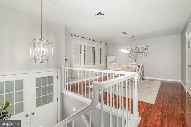 a view of staircase with railing and pendant lights
